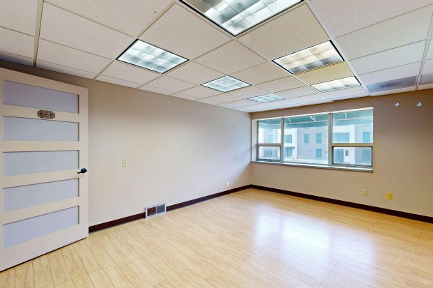 Vacant modern office space with large windows and natural light.
